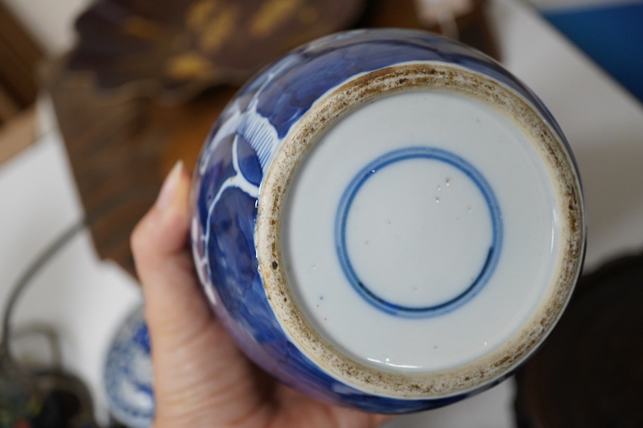 An 18th century Chinese blue and white dish, two jars (one without cover), a teapot and two carved wooden stands